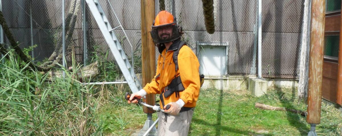 Medewerker van Stichting Aap met helm en apparaat in zijn handen.
