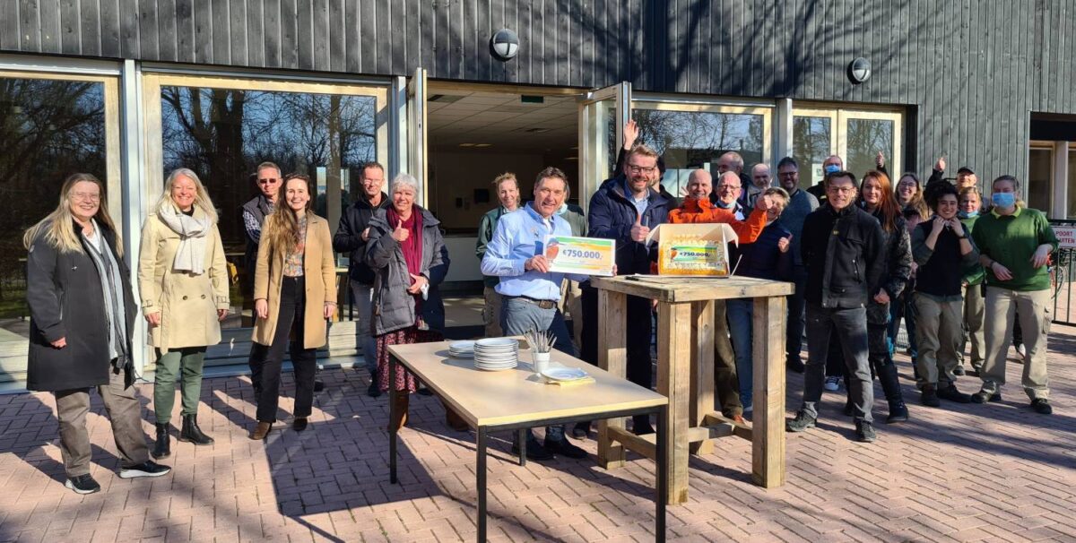 Directie en aanwezige medewerkers ontvangen een cheque bij AAP.